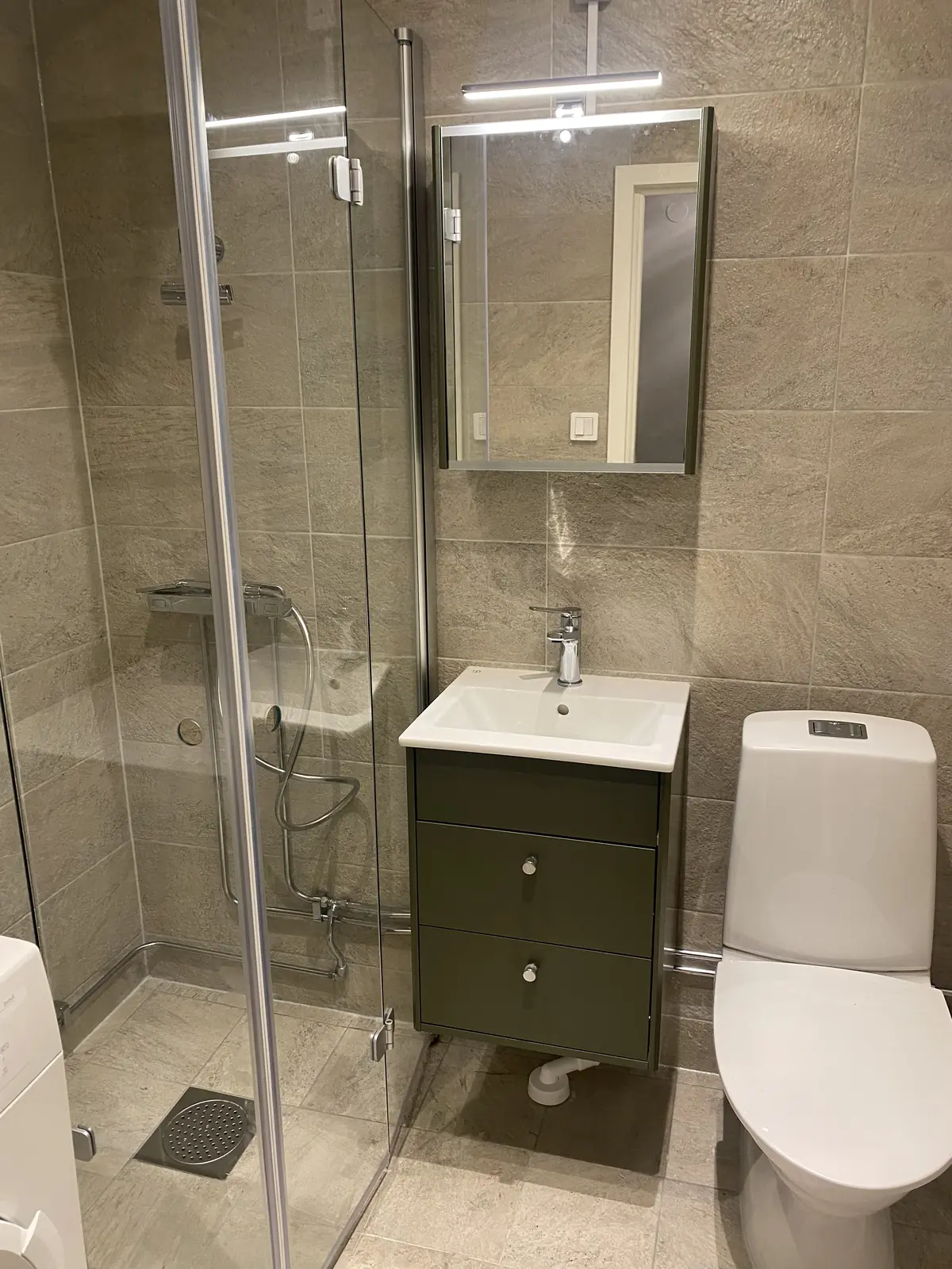 Dusjen, servanten og toalettet i det ferdige badet.