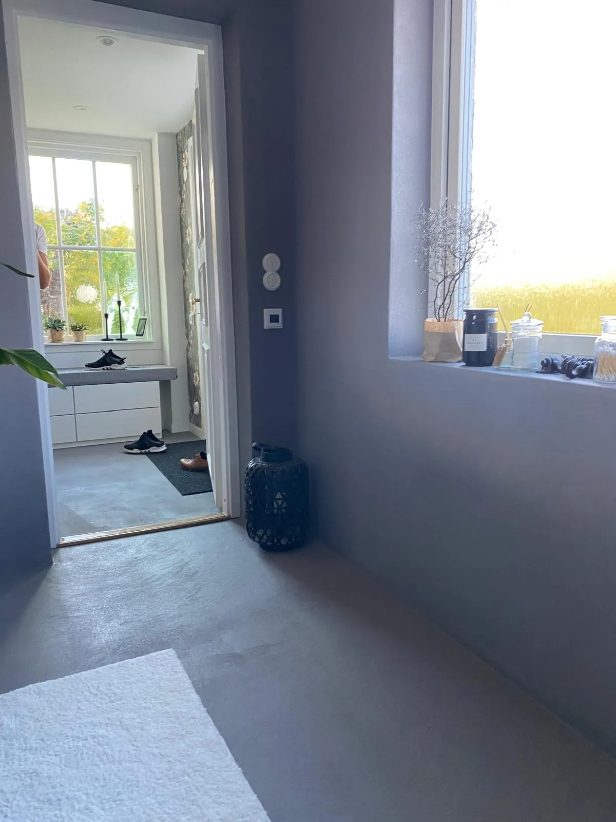 Badet sett mot døren, med vindu og grått gulv.