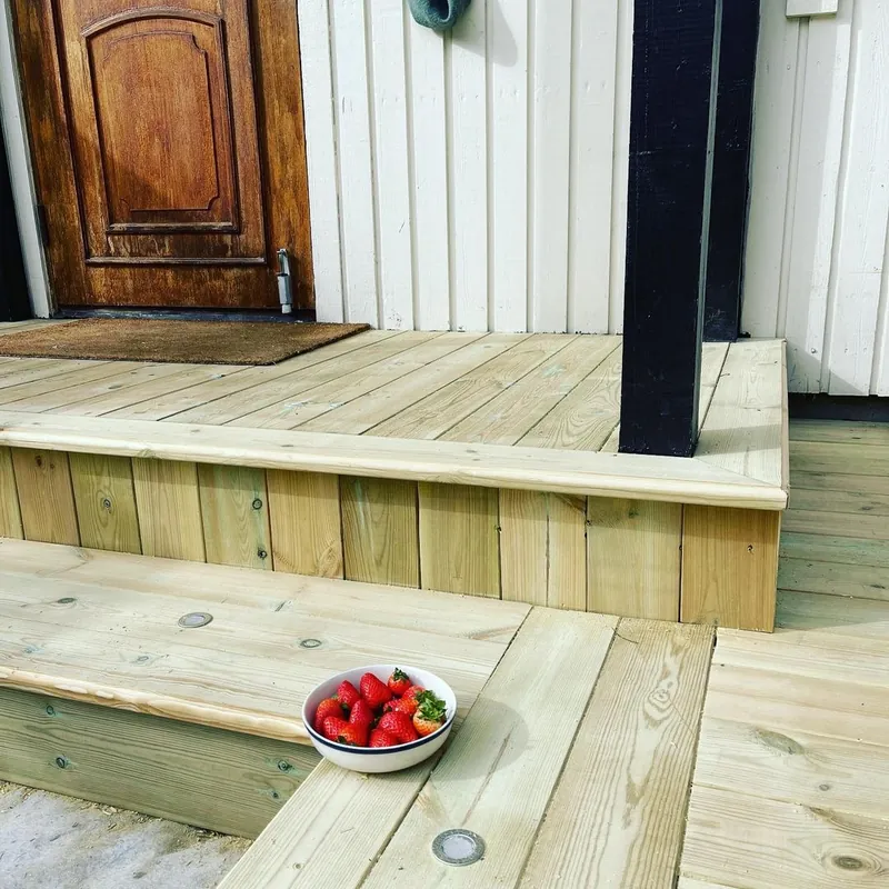 Platting og trinn i tre foran inngangsdøren.